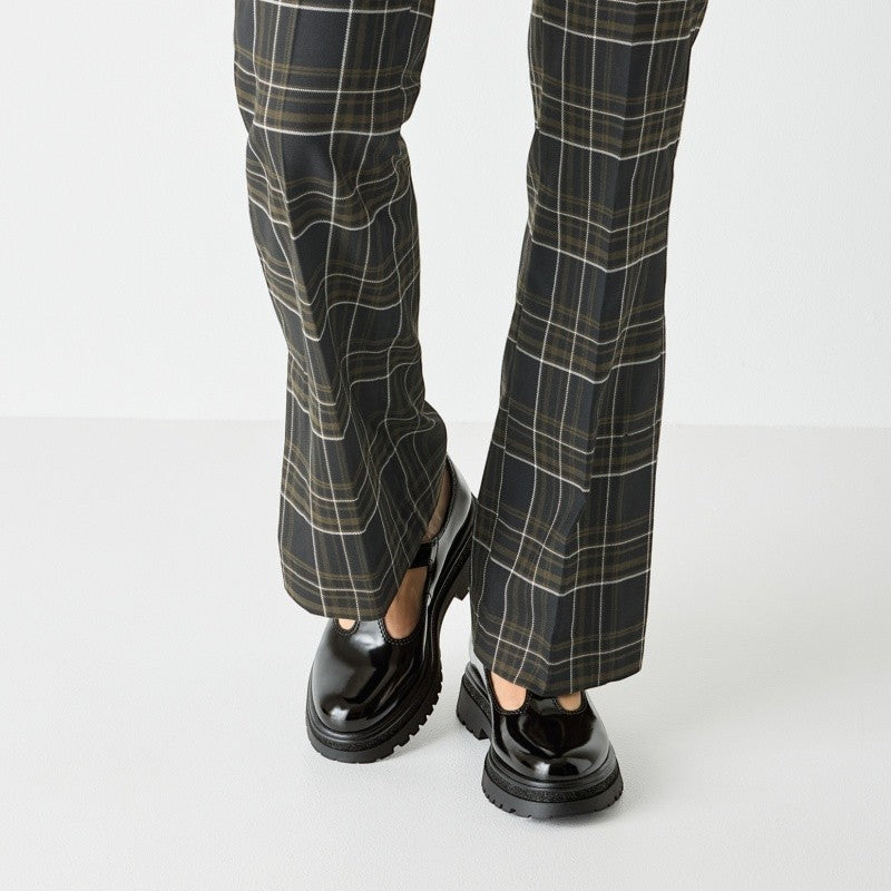 My Store black patent leather T-strap shoes with chunky sole and buckle detail, paired with plaid trousers.