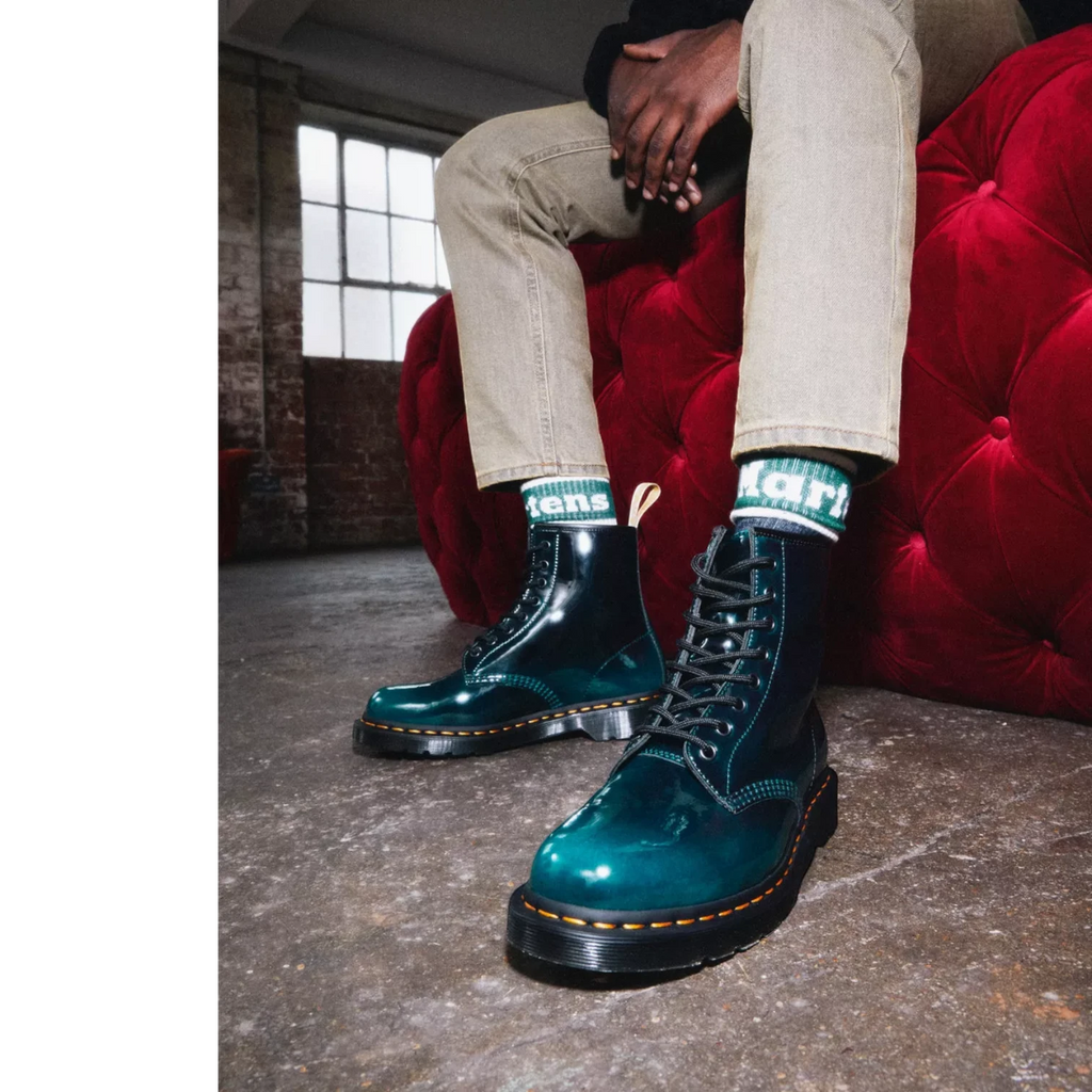 My Store Dr. Martens 1460 Gloss Vegan boots in teal patent synthetic material with black laces and yellow stitching.