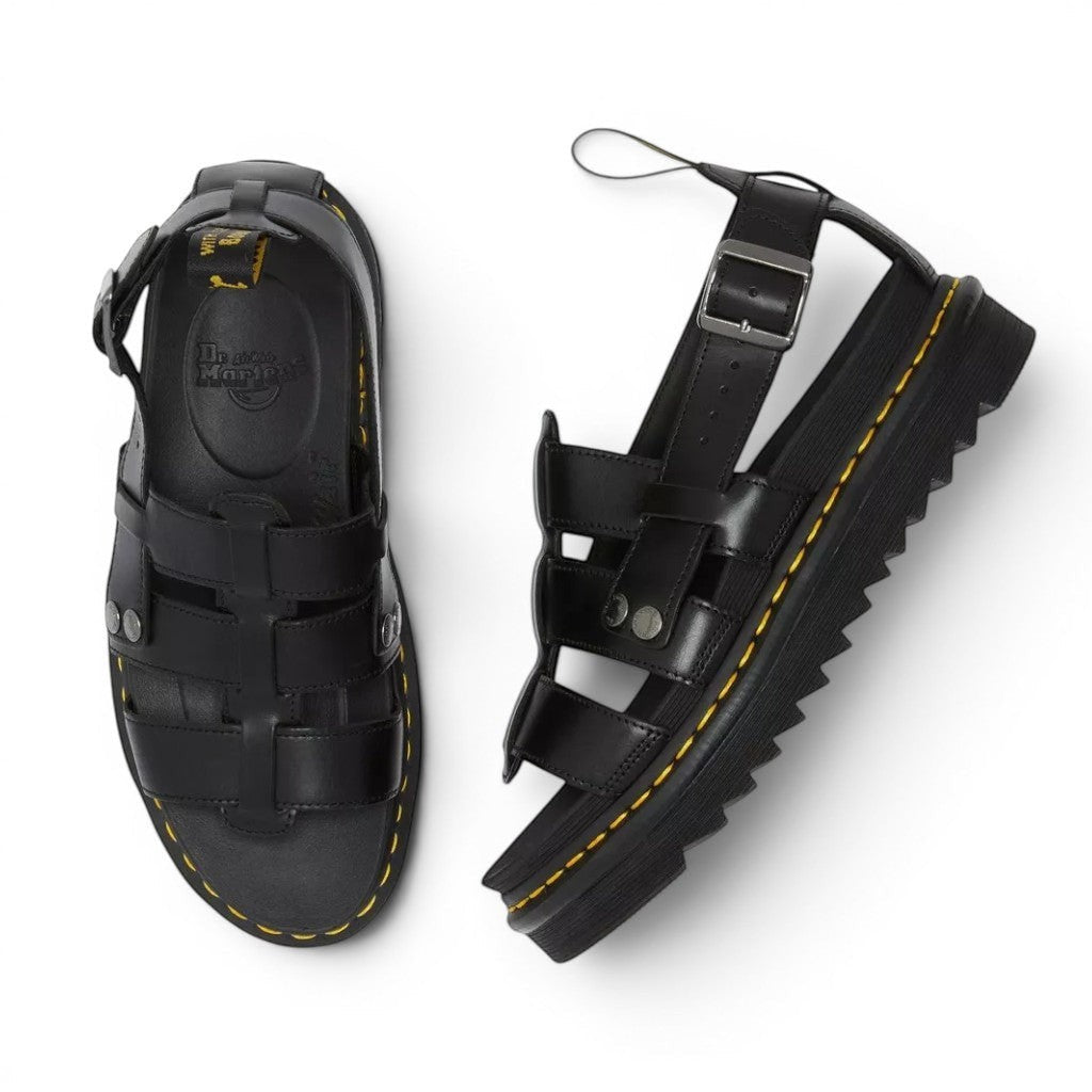 My Store Dr. Martens black Brando leather gladiator sandals with buckle strap and signature yellow stitching on a white background.