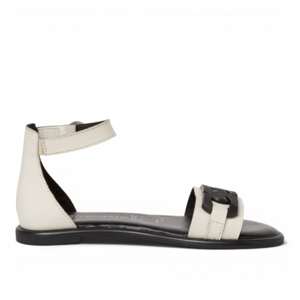 My Store white leather flat sandals with black buckle detail and ankle strap closure.