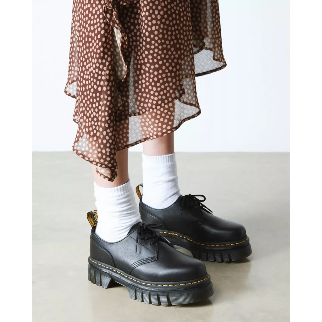 My Store Dr. Martens Audrick Nappa Lux black leather platform shoes with white socks and a brown polka dot dress.