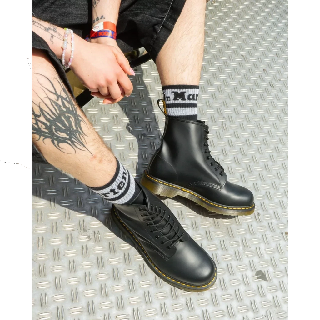 My Store black smooth leather Dr. Martens 1460 boots and 101 boots with yellow stitching and black laces.