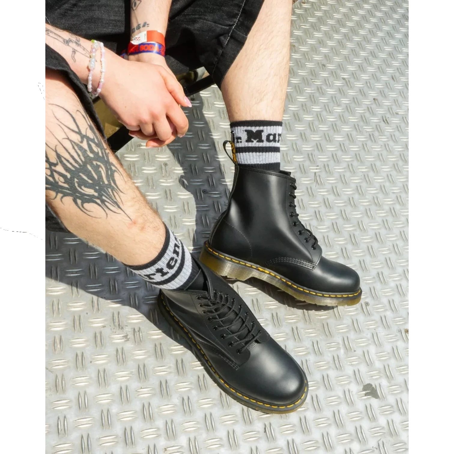 My Store black smooth leather Dr. Martens 1460 boots and 101 boots with yellow stitching and black laces.