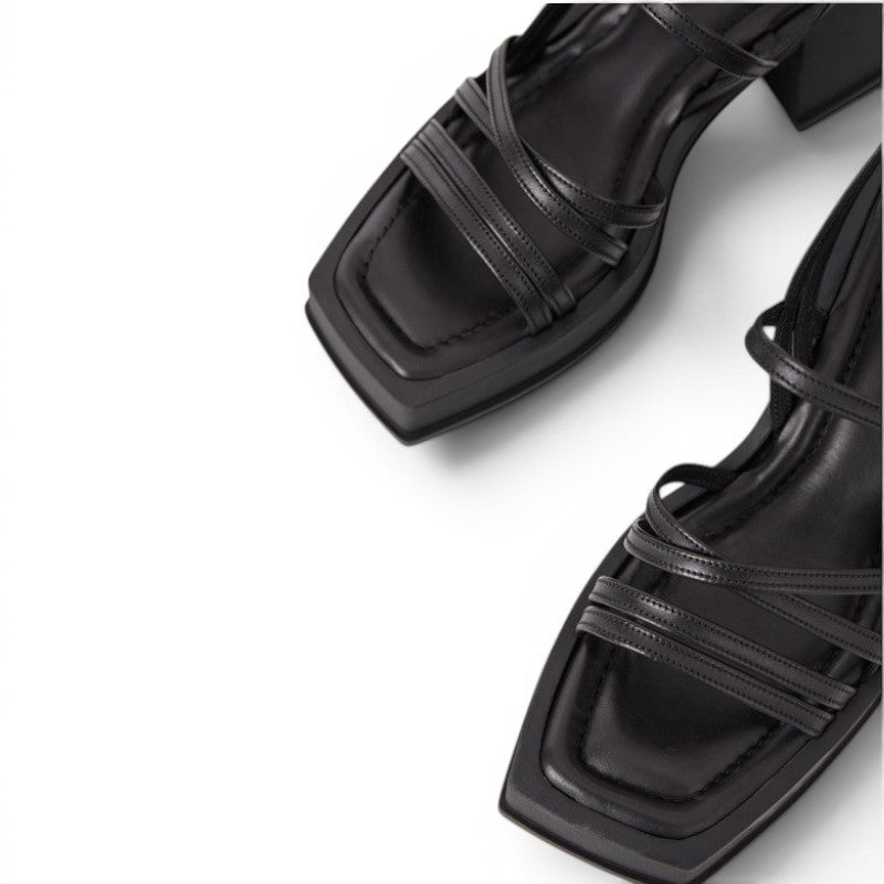ShoeShop black leather strappy platform sandals with a square toe and block heel.