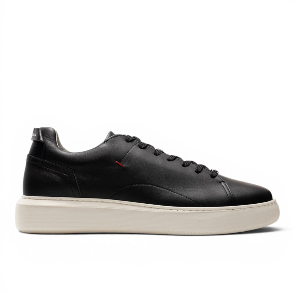 ShoeShop black leather low-top sneakers with a cream sole and red accent detail.