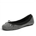 ShoeShop Buffalo black ballet flats adorned with rhinestones and a decorative bow with silver tips.