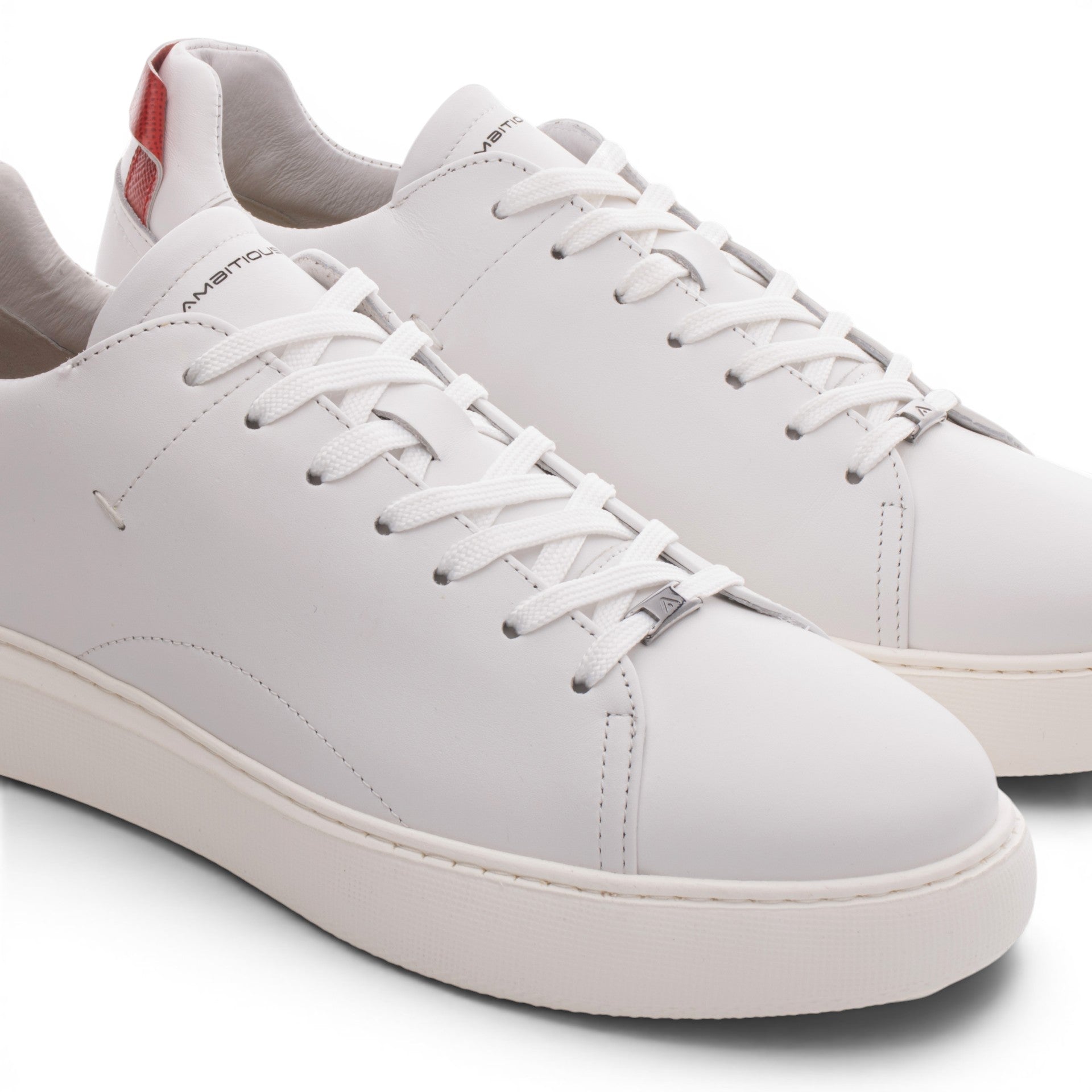 ShoeShop white leather low-top sneakers with red accent on heel tab and lace-up closure.