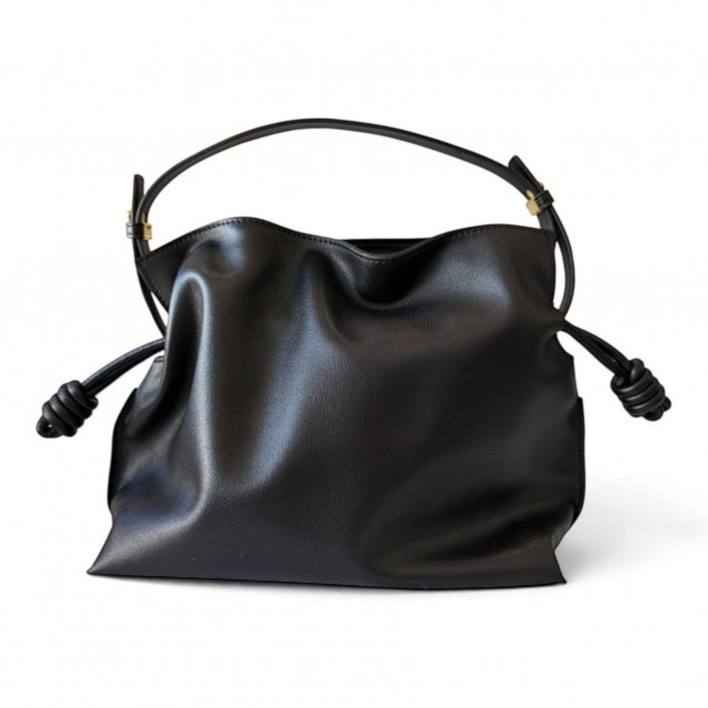 ShoeShop black leather handbag with a soft slouchy design, drawstring closure, and removable shoulder strap.