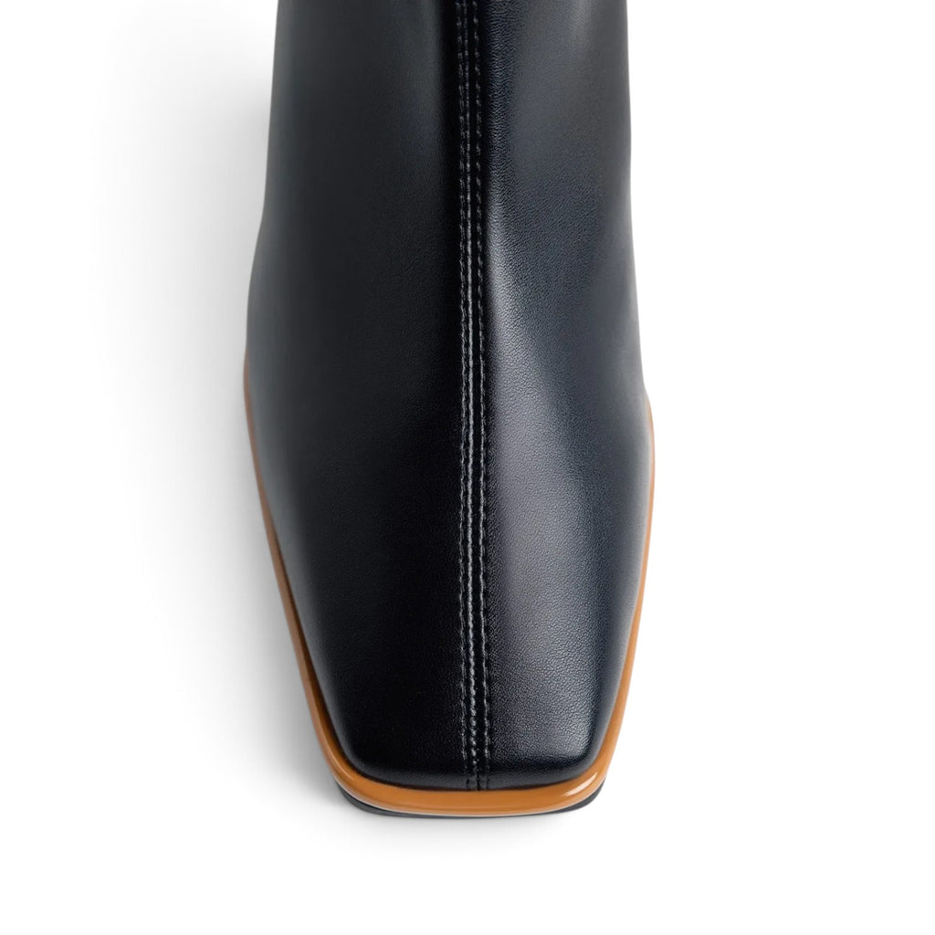 ShoeShop black leather ankle boot with a square toe and a contrasting tan sole, top-down view.