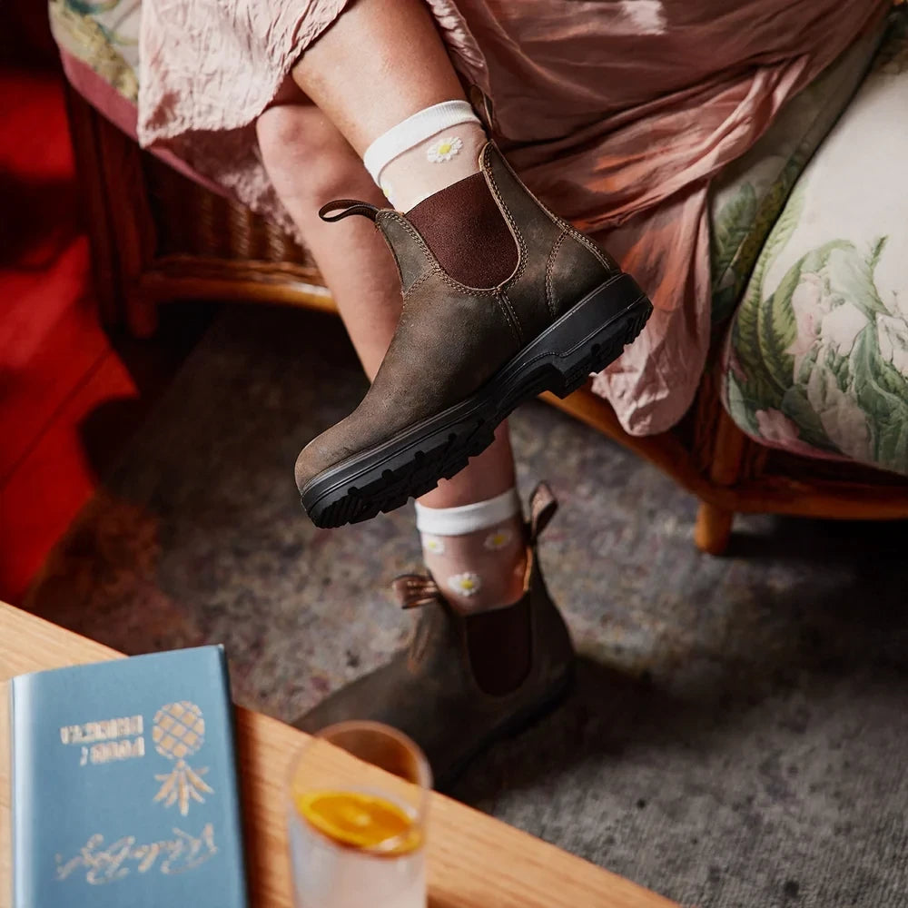 ShoeShop Blundstone 585 rustic brown leather Chelsea boots worn with floral socks in a cozy indoor setting