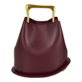 ShoeShop burgundy leather bucket bag with a structured gold metal handle on a white background