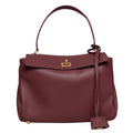ShoeShop burgundy leather handbag with a top handle, gold-tone turn-lock closure, and a decorative leather tag.