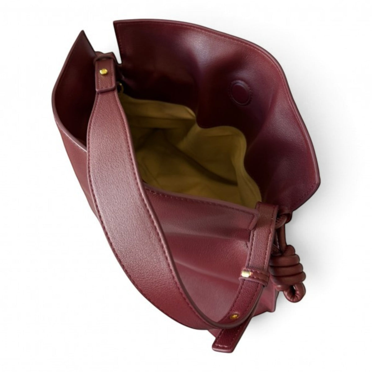 ShoeShop burgundy leather handbag with a drawstring closure, textile lining, and an adjustable shoulder strap.