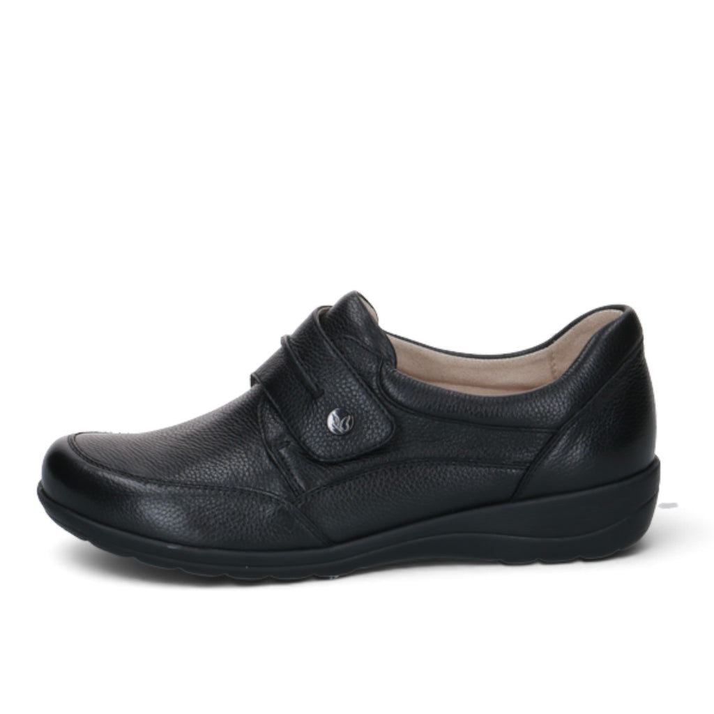 ShoeShop Caprice black leather comfort shoe with a wide H-fit, velcro strap closure, and durable rubber sole.