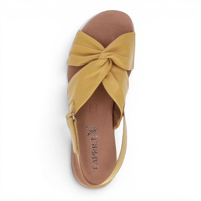 ShoeShop Caprice mustard yellow leather sandals with a knotted front strap and adjustable slingback buckle.