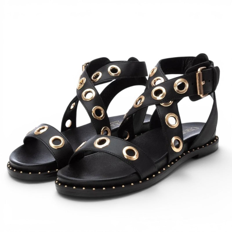 ShoeShop Carmela 162389 black leather flat sandals with gold eyelet details and buckle strap closure.