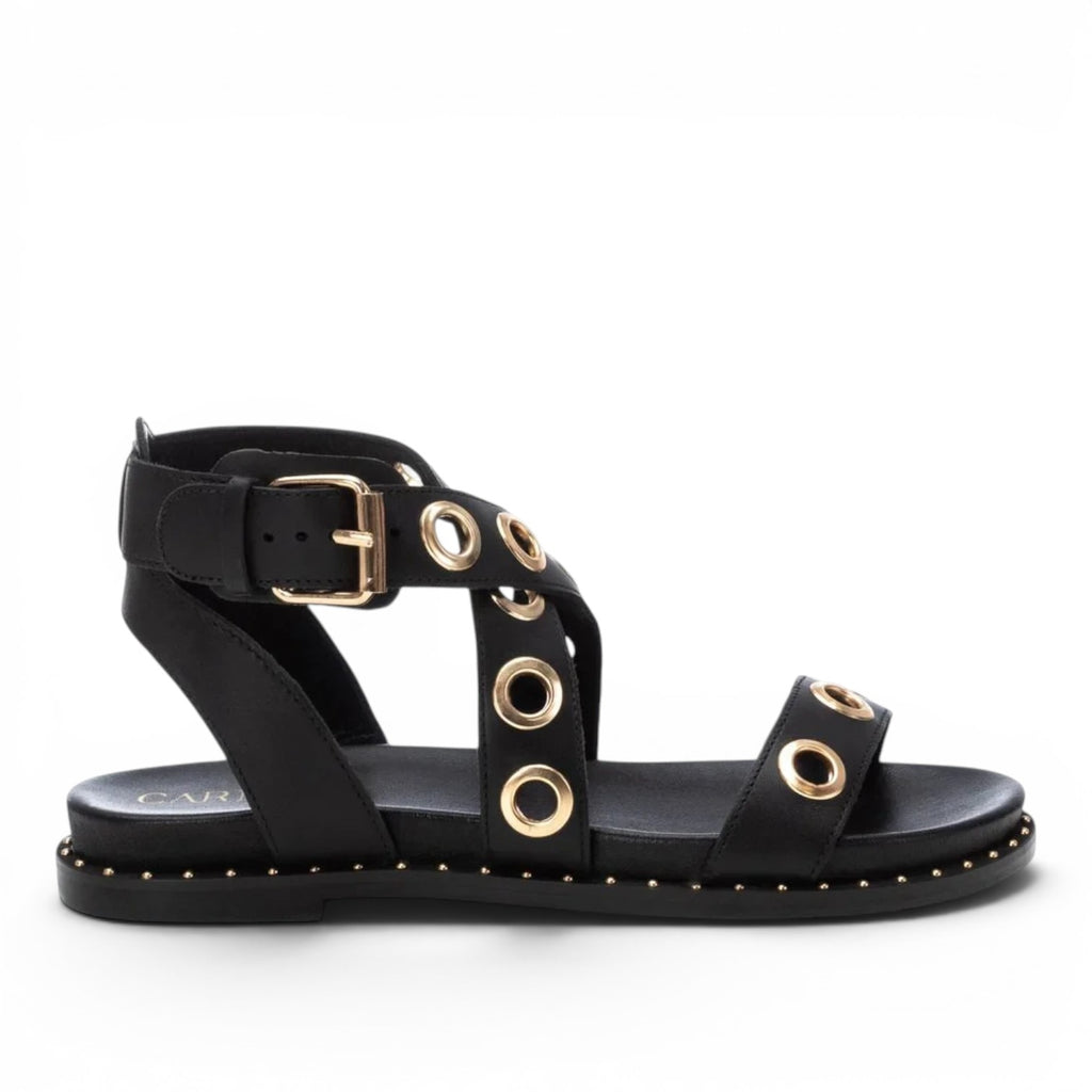 ShoeShop Carmela 162389 black leather flat sandals with gold eyelet details and an adjustable ankle strap buckle.