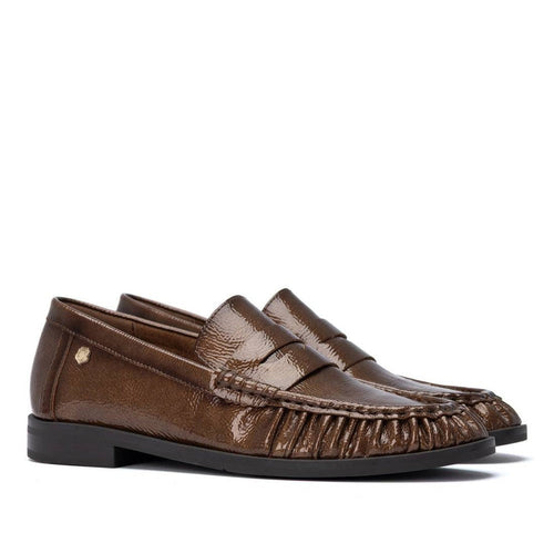 ShoeShop Carmela brown patent leather loafers with decorative pleated detailing and a durable rubber sole.