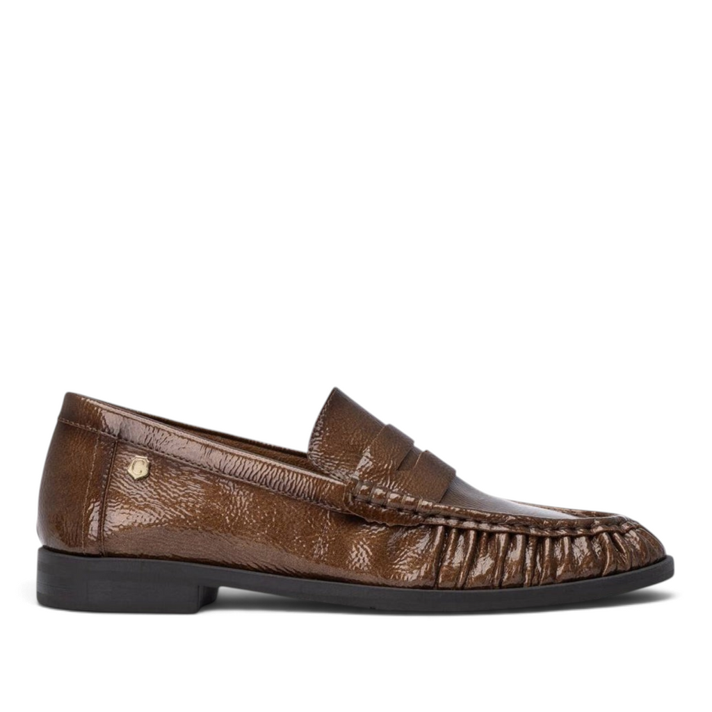 ShoeShop Carmela brown patent leather loafers with a decorative pleated front and a durable rubber sole.