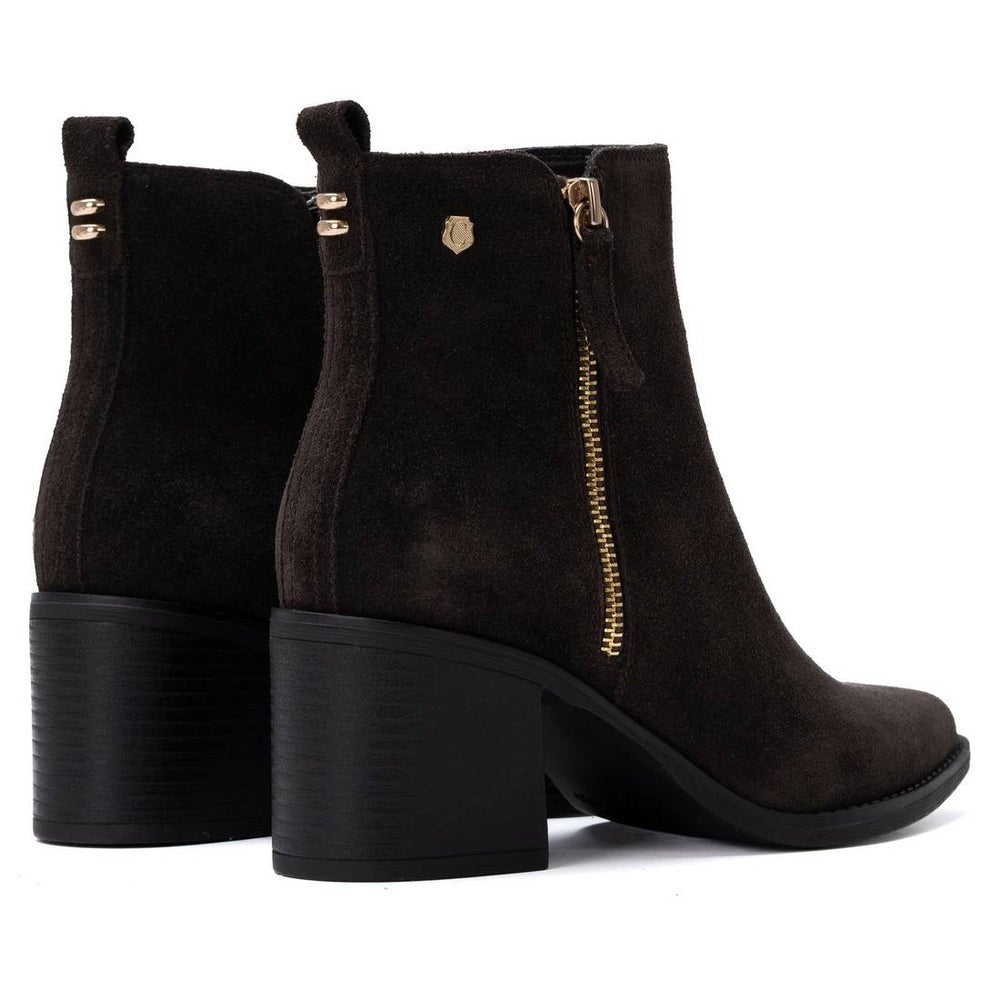 ShoeShop Carmela dark brown suede ankle boots with a block heel, side zipper, and gold-tone hardware details.