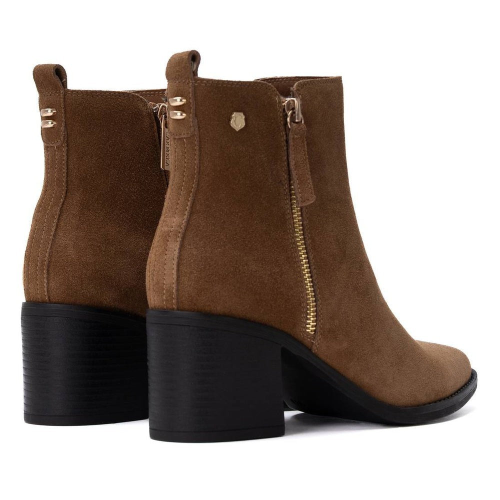 ShoeShop Carmela brown suede ankle boots with a block heel, side zipper, and pull tab, viewed from the back.