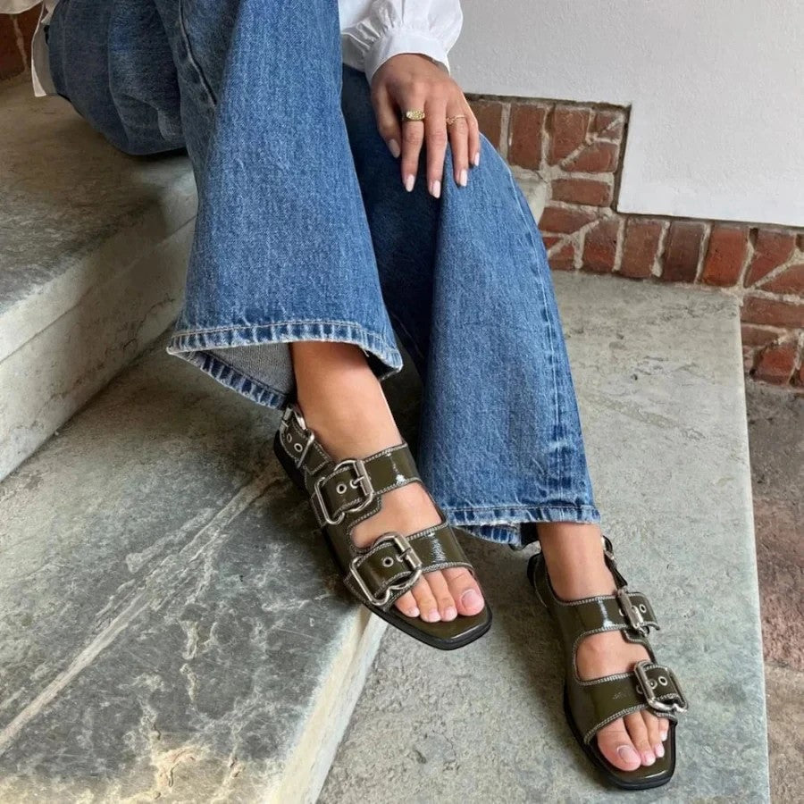 ShoeShop Copenhagen CS8461 olive green patent leather sandals with chunky silver buckles worn with blue jeans.
