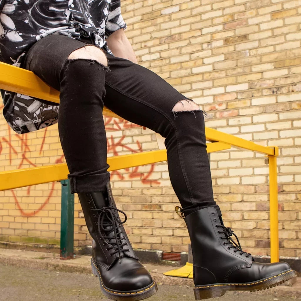 ShoeShop Dr. Martens 11857001 black patent leather lace-up boots with yellow stitching worn by a man