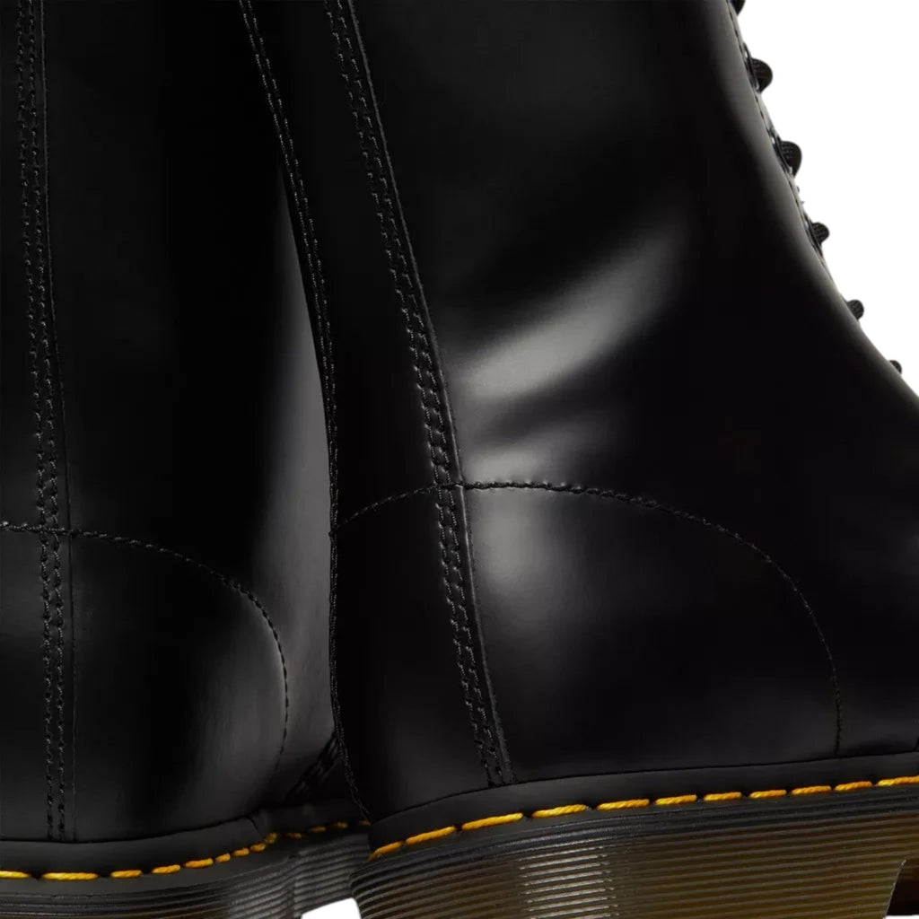 ShoeShop Dr. Martens black patent leather boots featuring iconic yellow stitching and durable PVC soles