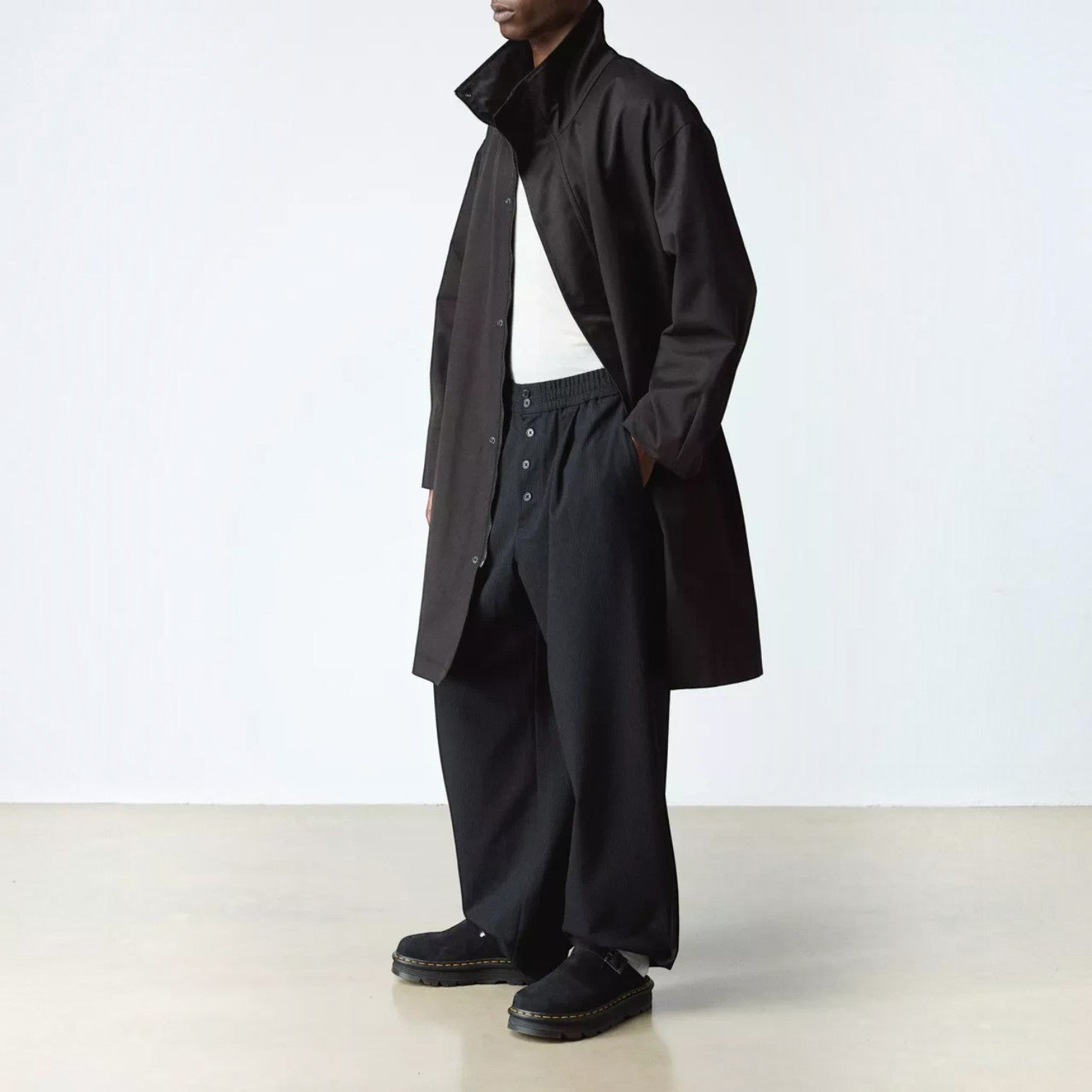 ShoeShop Dr. Martens Zebzag black suede casual slingback shoes worn by a model in a long coat and trousers