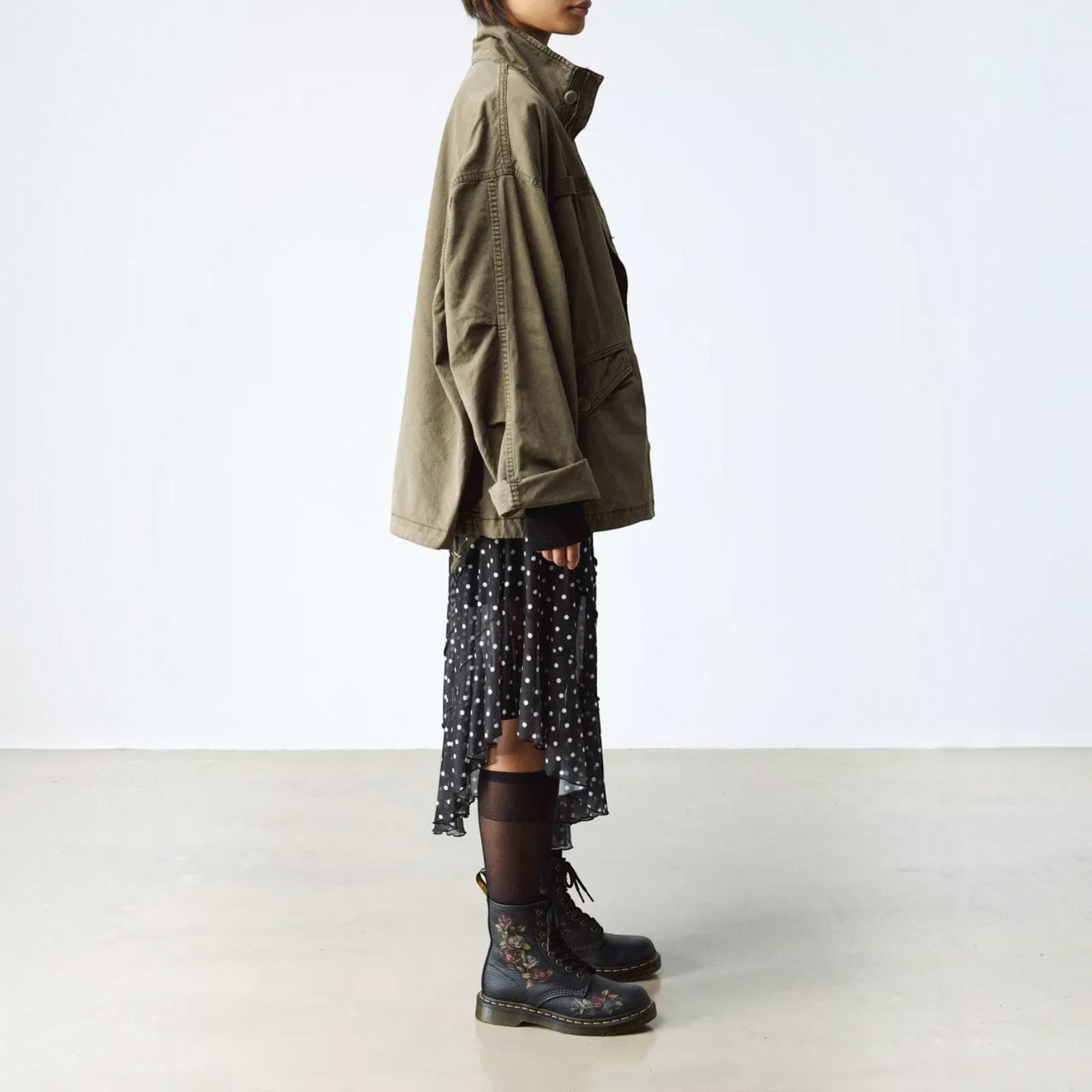 ShoeShop Dr. Martens 1460 Decayed Roses black leather boots with floral print, worn with a skirt and olive jacket