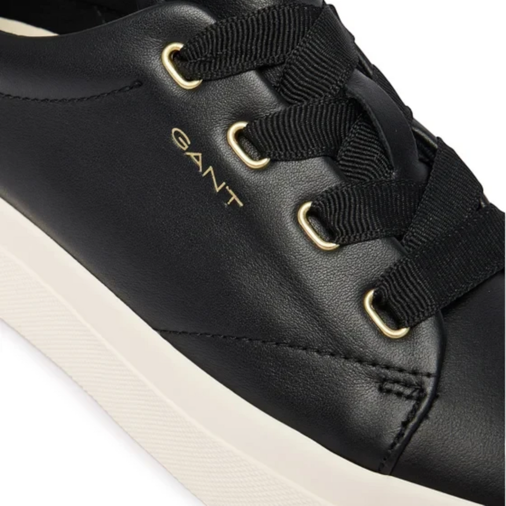 ShoeShop GANT black leather sneakers with gold eyelets, wide black ribbon laces, and a white rubber sole.