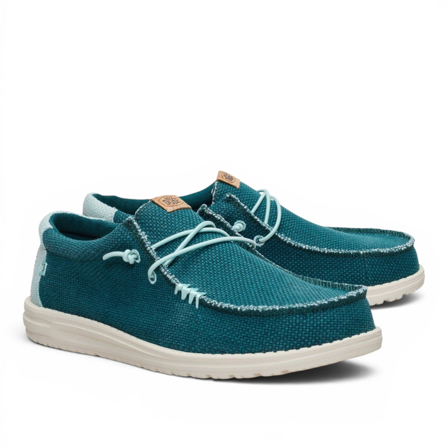 ShoeShop Hey Dude teal canvas slip-on shoes with white textured soles and decorative lace-up detail