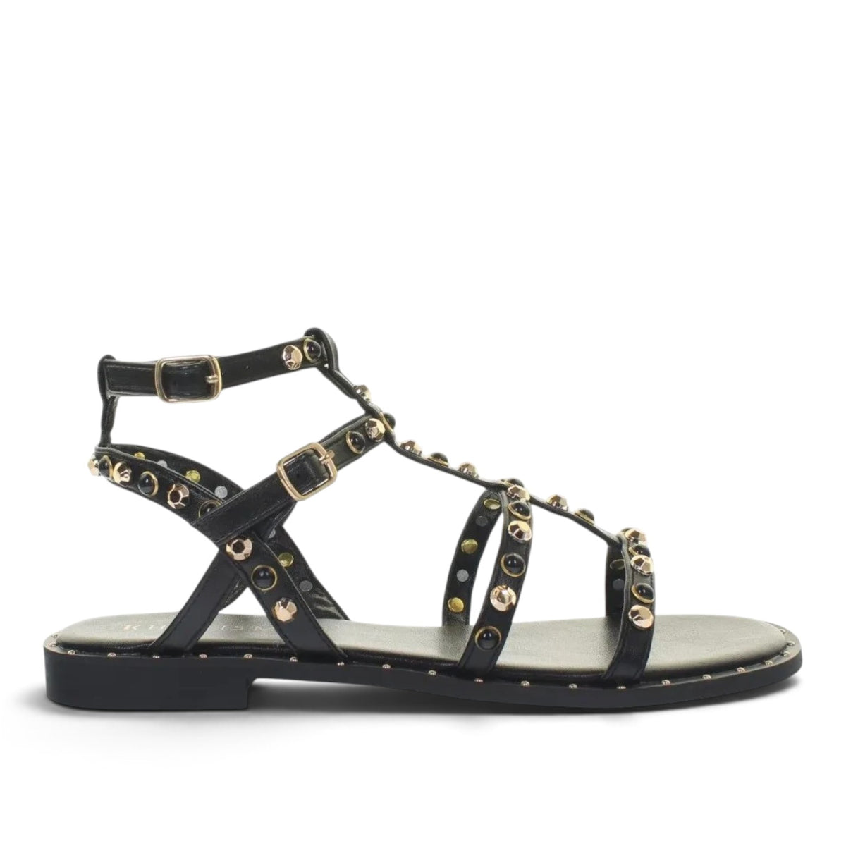 ShoeShop Kharisma black flat sandals featuring gold and black stud embellishments and adjustable ankle straps.