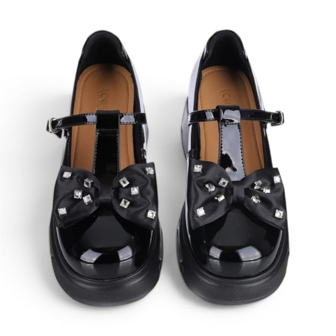 ShoeShop Loretta Vitale black patent leather T-strap shoes with a rhinestone-embellished bow and chunky platform sole.