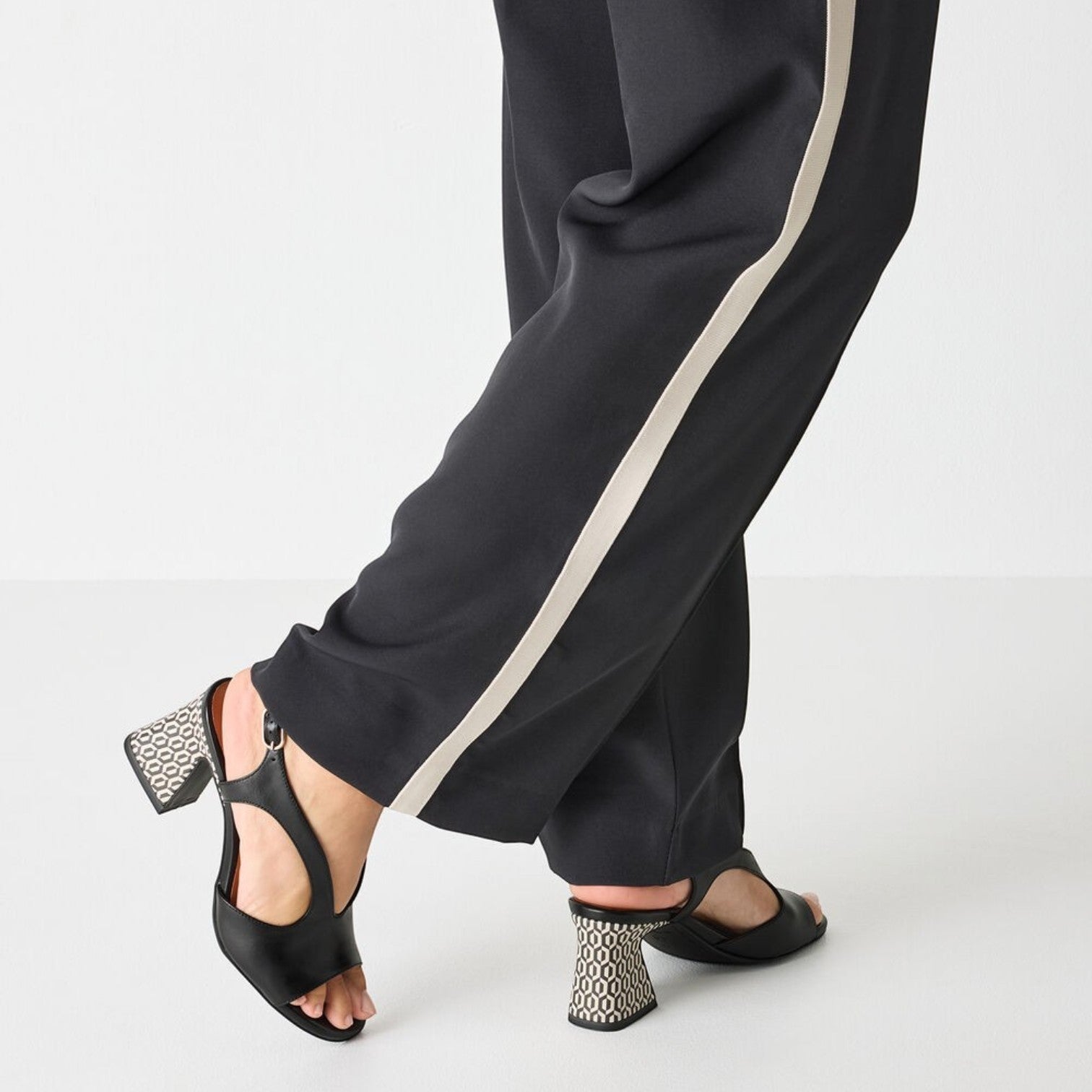 ShoeShop Tamaris black open-toe sandals with a patterned block heel worn with black trousers