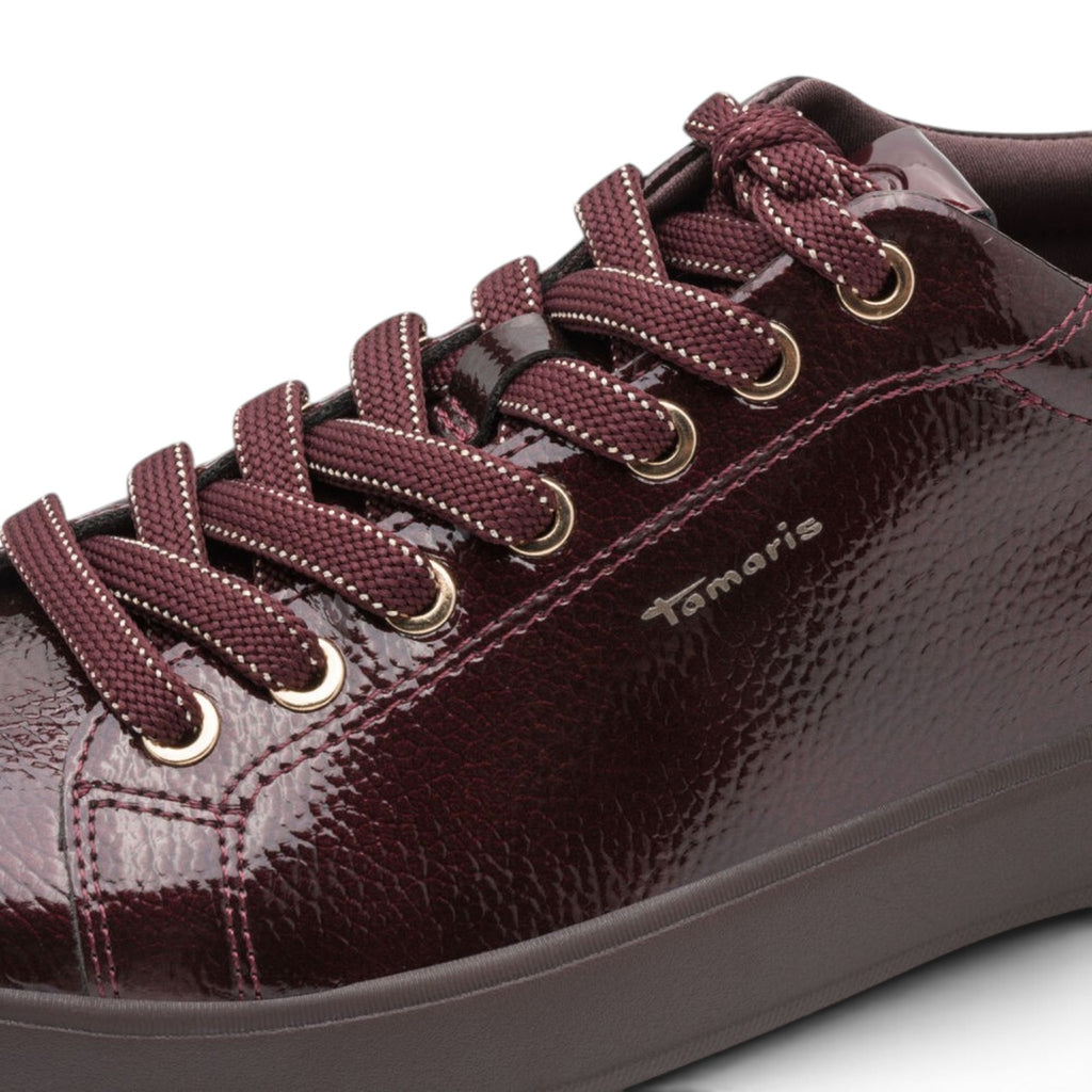 ShoeShop Tamaris burgundy patent leather lace-up sneaker with gold eyelets and textured finish