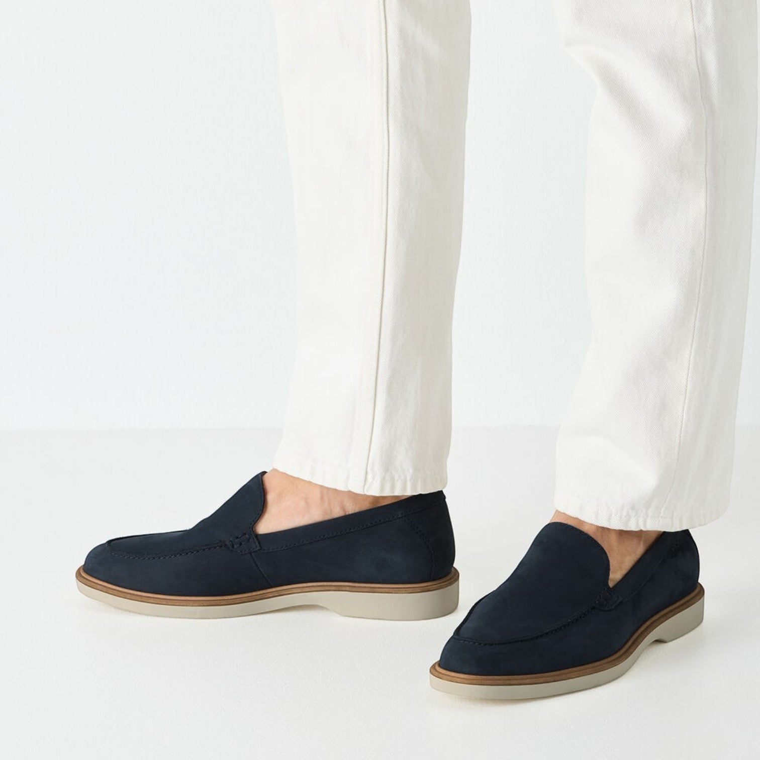 ShoeShop Tamaris navy blue suede loafers with a light grey sole worn with white trousers
