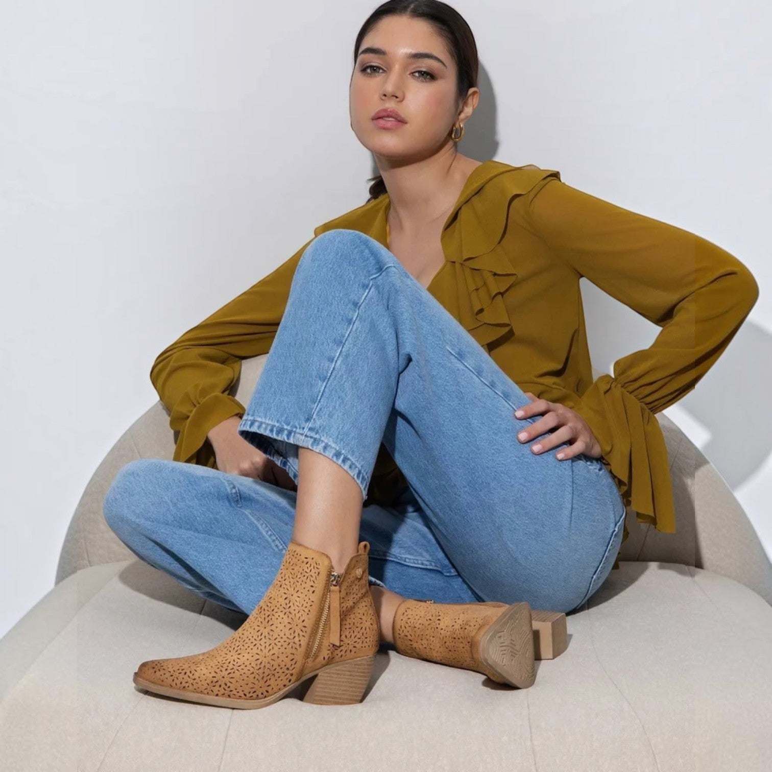 ShoeShop XTI 145037 tan ankle boots with laser-cut floral patterns and side zippers worn by a seated woman