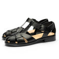 ShoeShop black leather woven fisherman sandals with buckle closure and rubber sole.